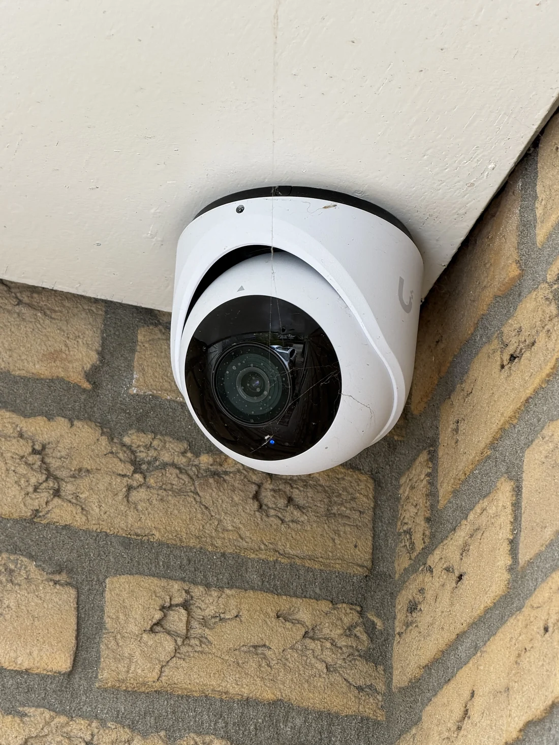 Dome-camera strak in de hoek van de gevel gemonteerd