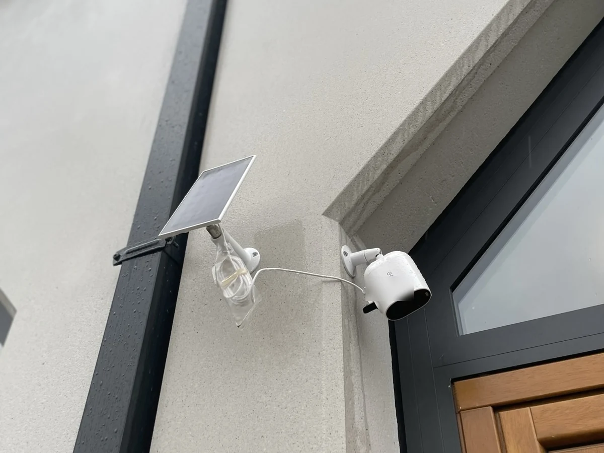 Accucamera met een los zonnepaneel en snoeren die er open en bloot bij hangen