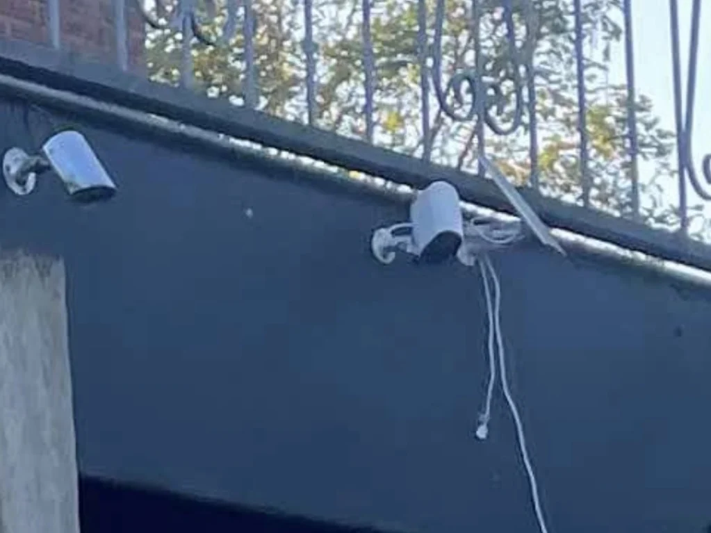 Twee camera's op een luifel met een kabel die er los naar beneden bij hangt