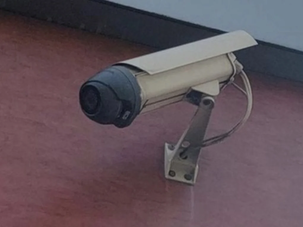 Oudere camera met een kabellus die achter de behuizing langs hangt