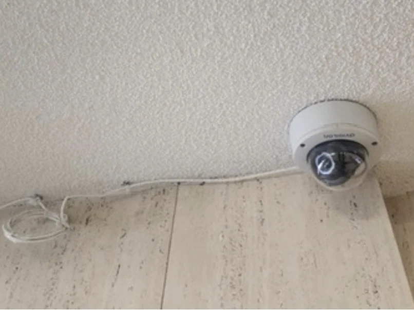 Binnencamera met een opgerolde kabel los over het plafond gelegd