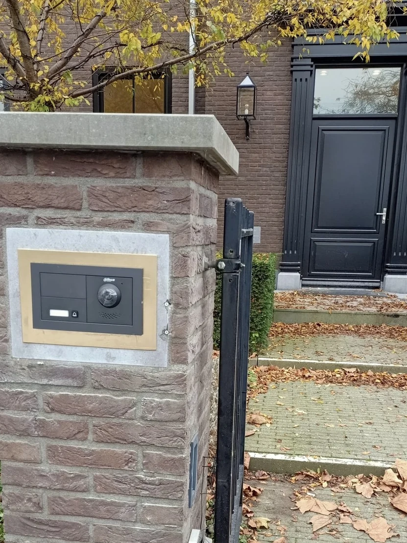 Intercom ingebouwd in de poortpijler, met een natuurstenen omlijsting