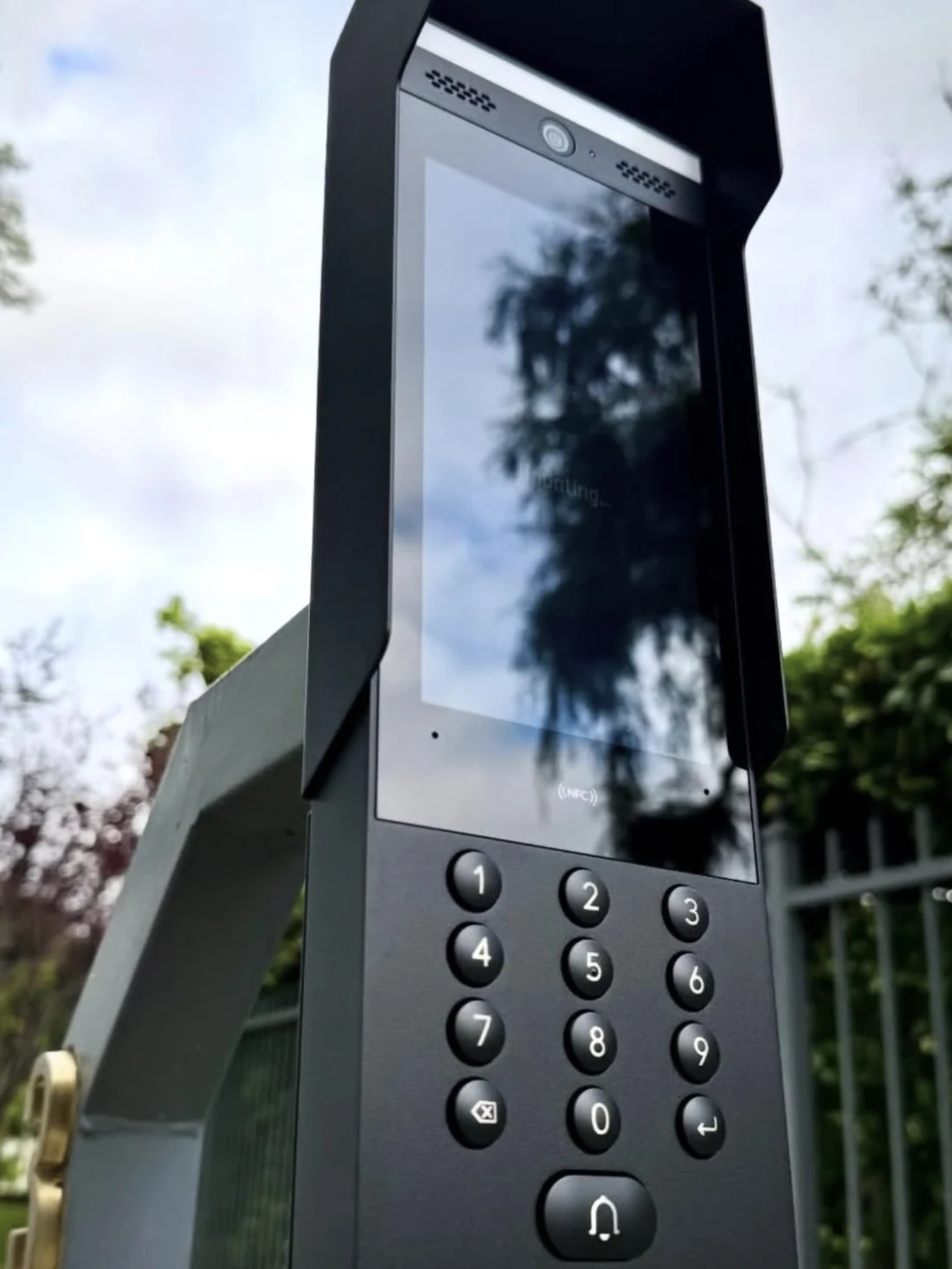 Video-intercom met toetsenbord op een paal naast het toegangshek