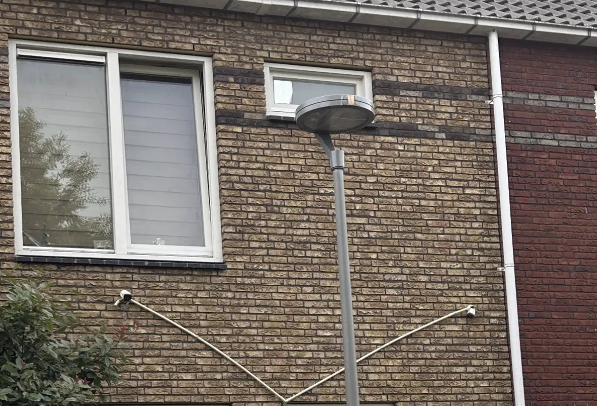 Voorbeeld van slordig werk: zichtbare camerakabels los over een gevel