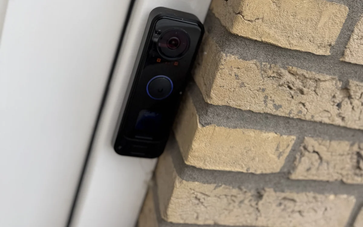 Video-deurbel en codeklavier naast de voordeur van een woning