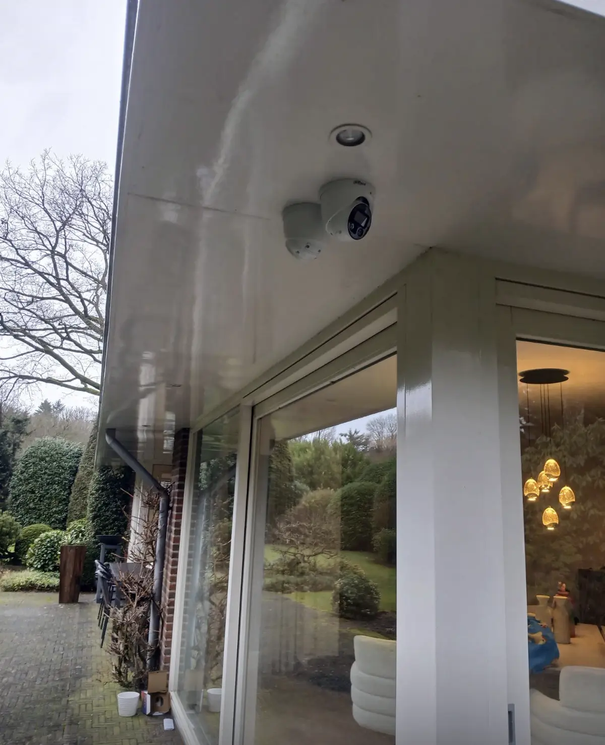 Camera strak in de hoek van een woning gemonteerd, gericht op het eigen terrein