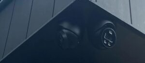Twee zwarte camera's naast elkaar in de hoek onder een zwart overstek